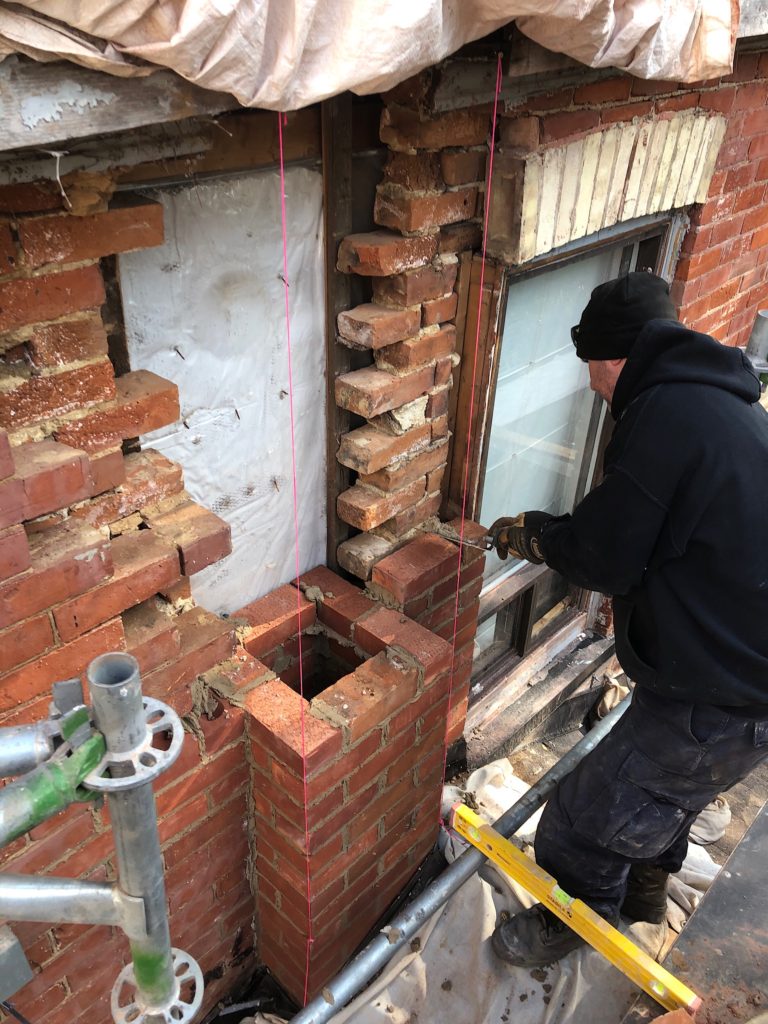 Working on a brick chimney